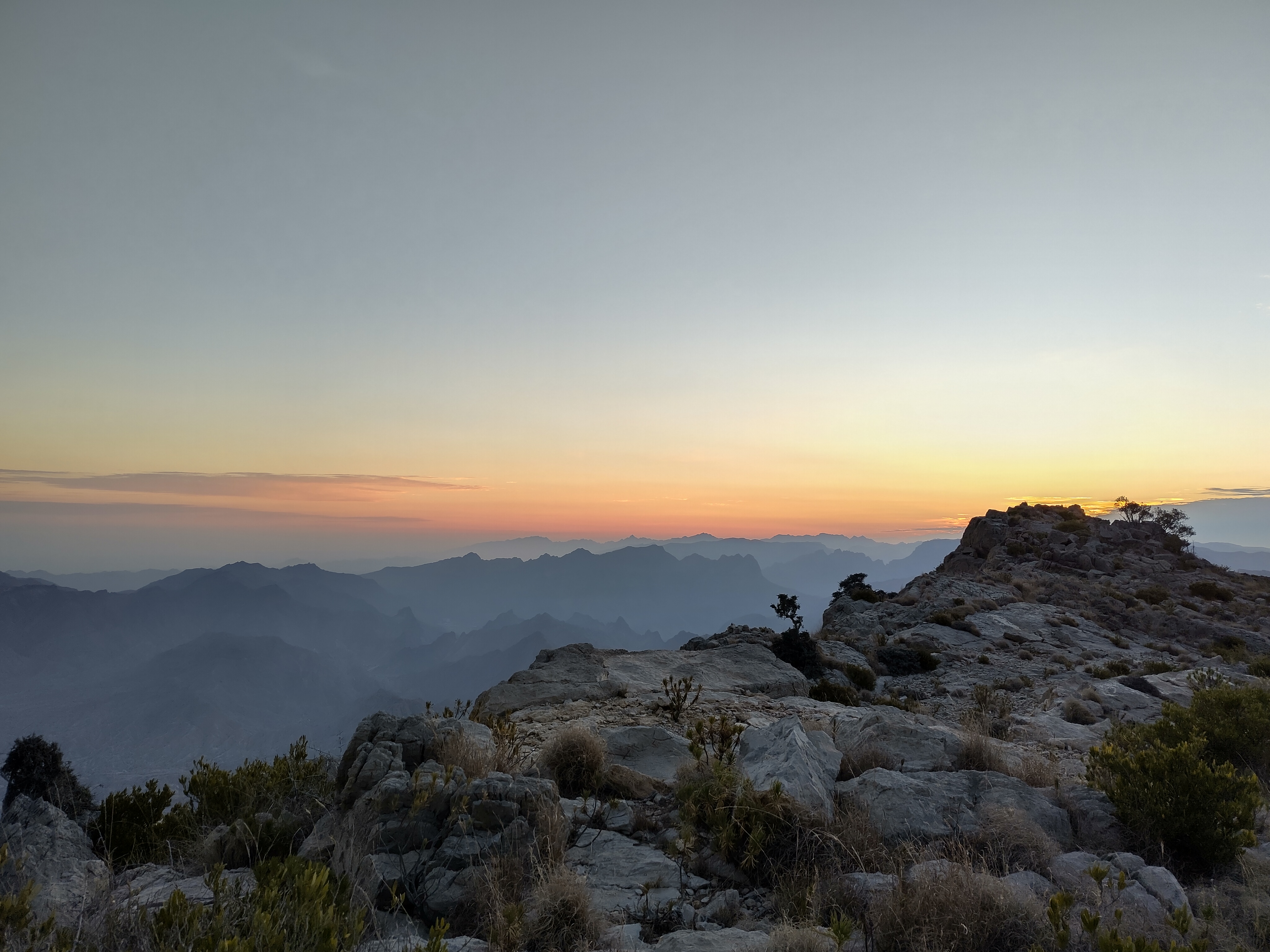 View looking east over the Hajar mountains from Jebel Shams at dawn.